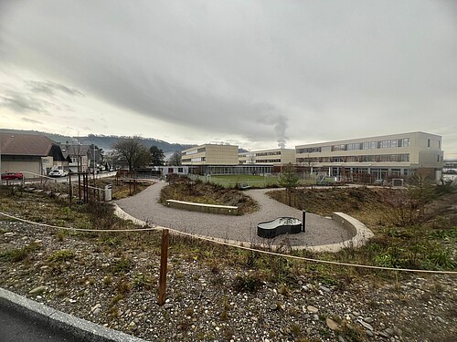 Des talus végétalisés en lieu et place des clôtures: l’installation d’infiltration a cédé la place à un espace public ouvert.