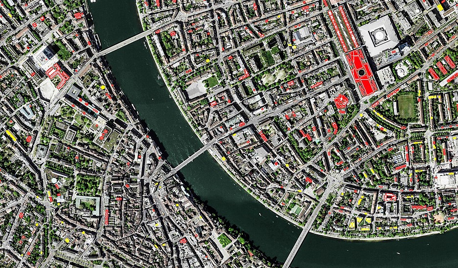 Détectées par l’intelligence artificielle: les installations PV (rouge) et les installations solaires thermiques (jaune) dans le centre-ville de Bâle. En haut à droite, le toit du centre des expositions équipé d’un système photovoltaïque. 