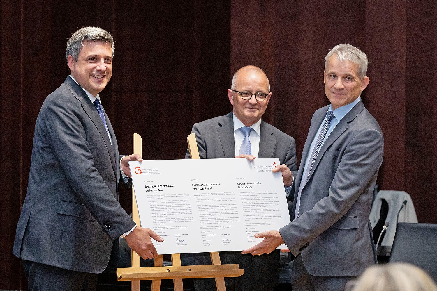Remise de la déclaration au conseiller fédéral Beat Jans (à droite) par Hanspeter Hilfiker (au centre), maire d’Aarau, président de l’UVS, et le conseiller aux Etats Mathias Zopfi (à gauche), président de l’ACS, dans la salle de la coupole du Palais fédéral.